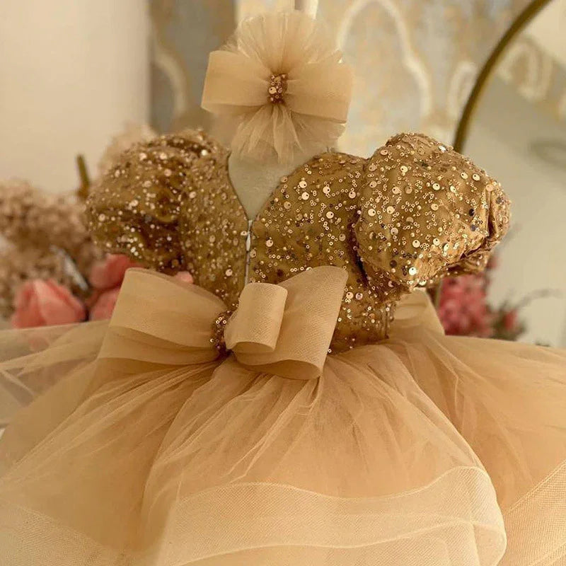 Gold sequin toddler dress with puff sleeves, tulle skirt, and matching headband bow
