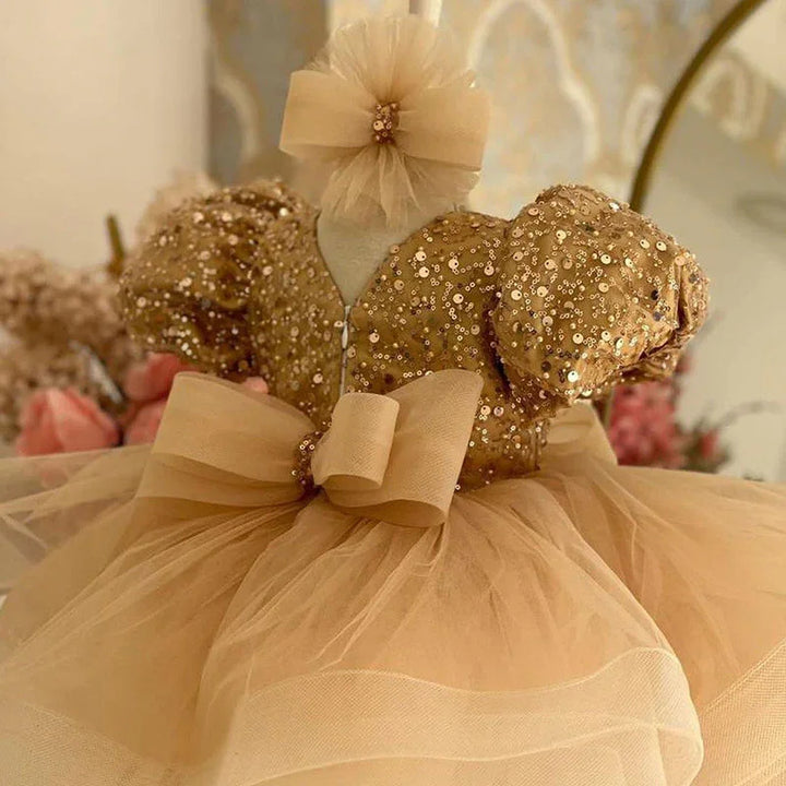 Gold sequin toddler dress with puff sleeves, tulle skirt, and matching headband bow