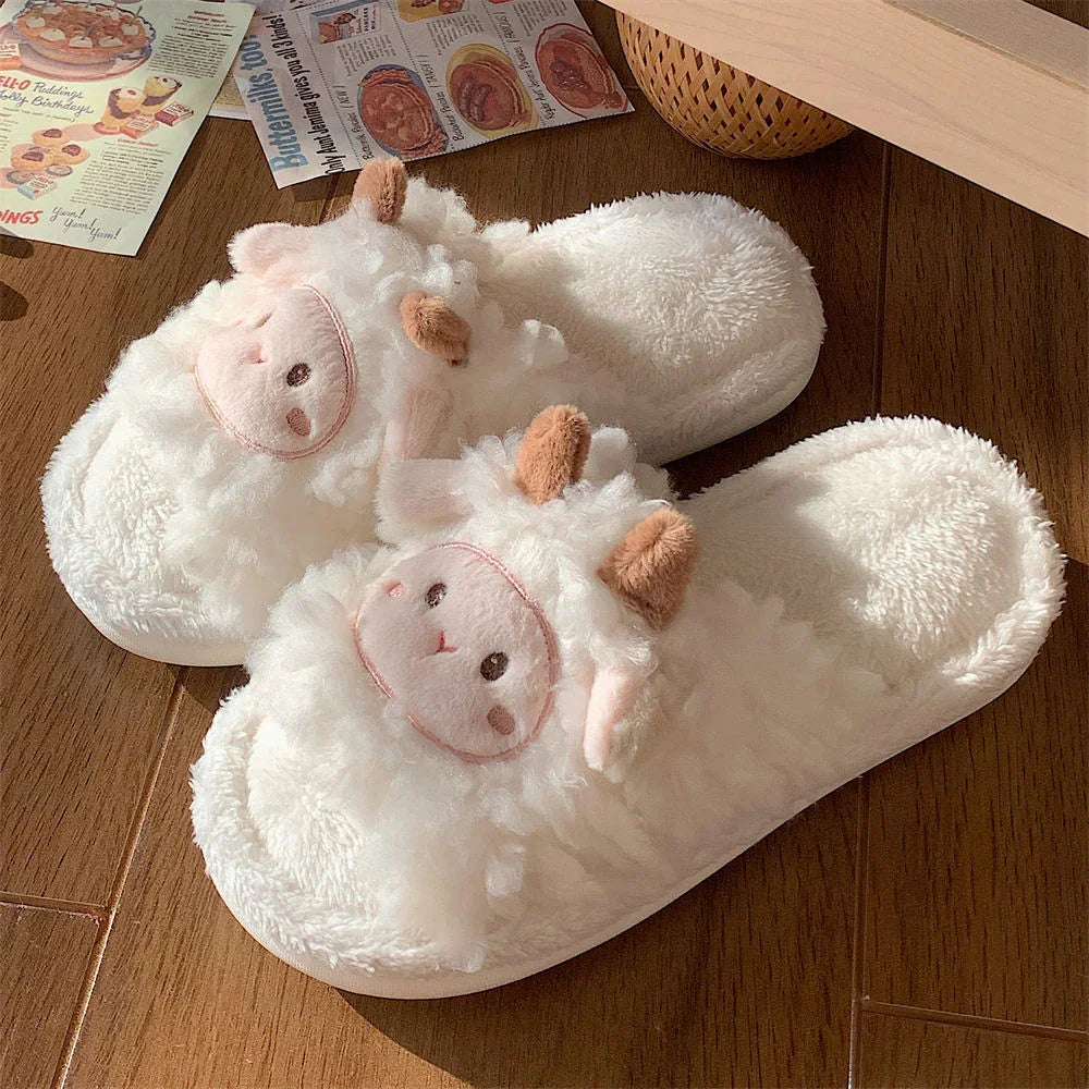 Cozy white fleece slippers with cute sheep faces and brown ears on wooden floor