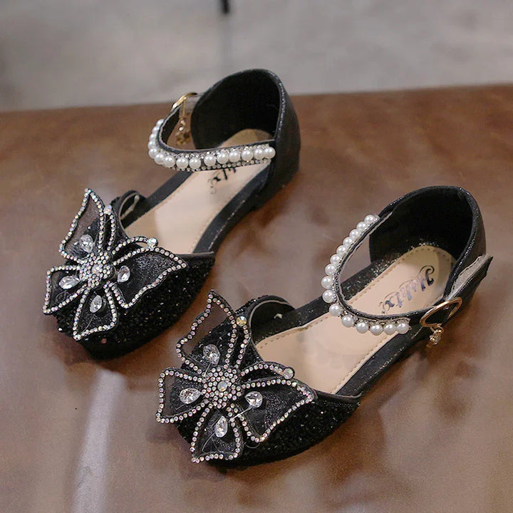 Black girls' dress shoes with pearl ankle straps and large rhinestone butterfly decorations