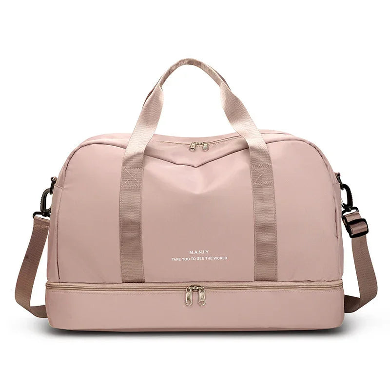 Light pink travel duffel bag with top handles, shoulder strap, and bottom zip compartment