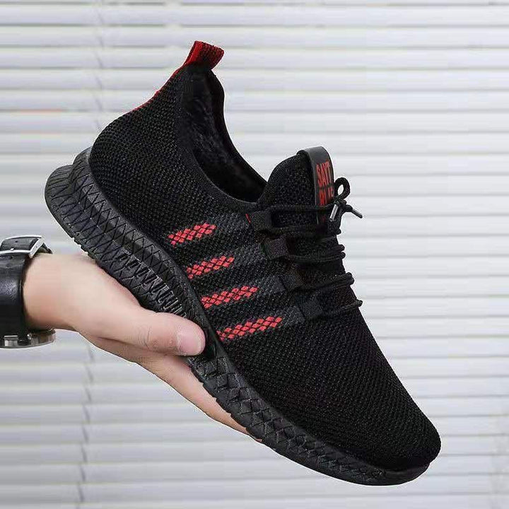 Hand holding black and red lightweight mesh running shoe with textured sole and lace-up design