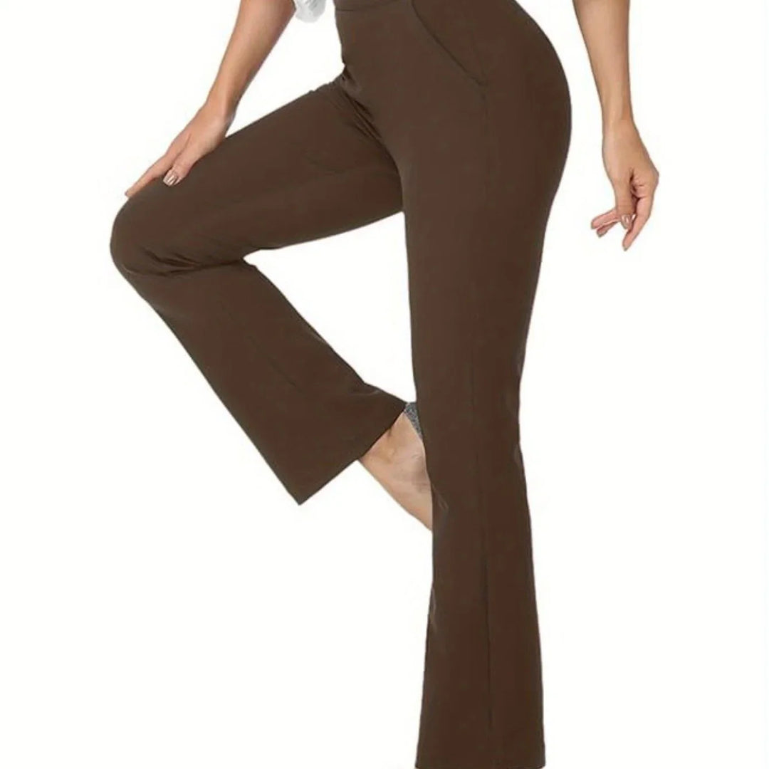 Close-up of woman wearing brown fitted flare pants with hand resting on bent knee