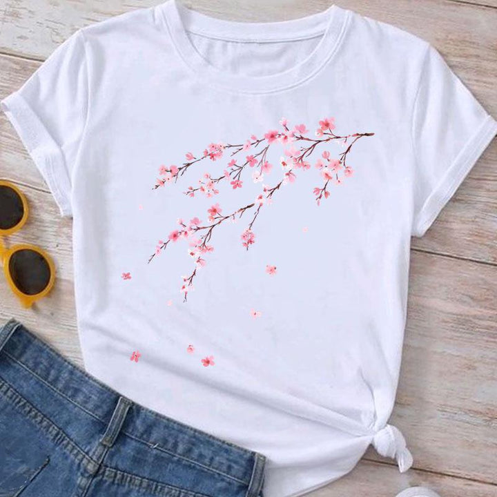 White t-shirt with pink cherry blossom branch print paired with blue jeans and yellow sunglasses