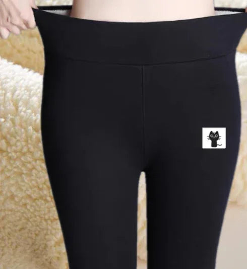 Close-up of hands stretching the waistband of black leggings with a small black cat logo on thigh