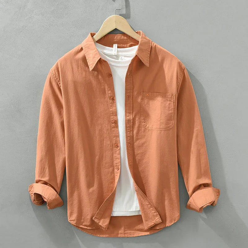 Rust orange casual long-sleeve button-up shirt with chest pocket over white T-shirt on wooden hanger