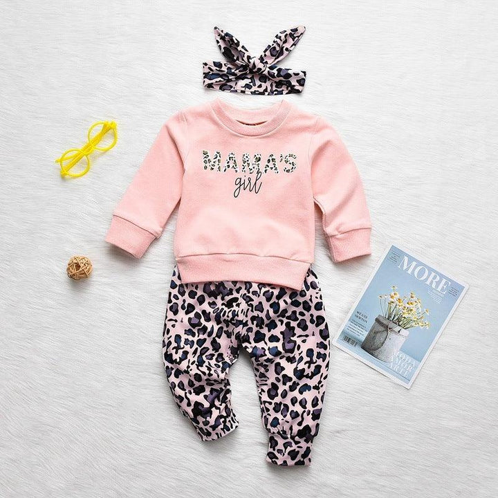 Pink baby outfit set with "MAMAS girl" sweatshirt, leopard print pants and matching headband on white background