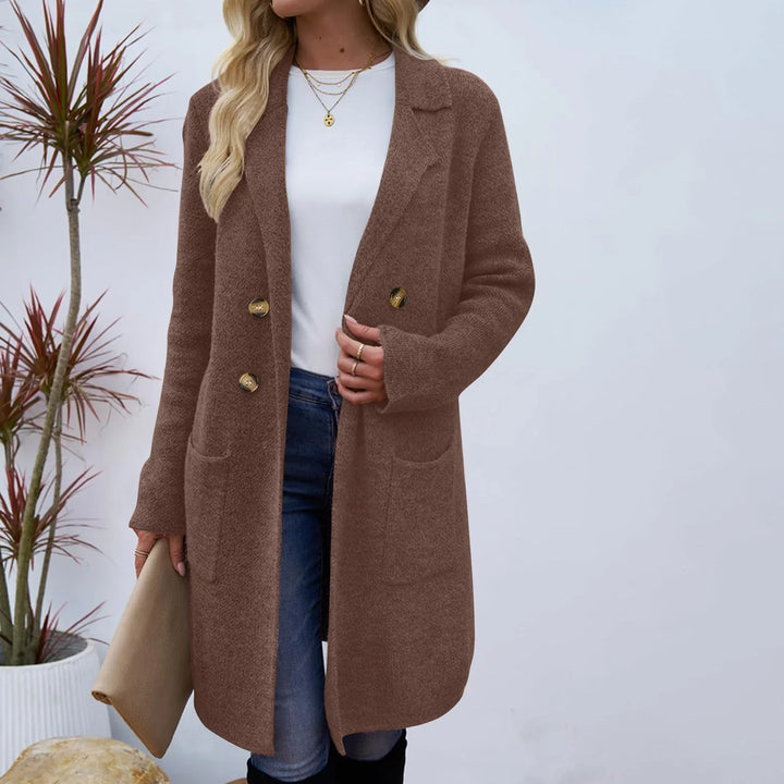 Woman wearing brown double-breasted wool coat with gold buttons, white top, and blue jeans