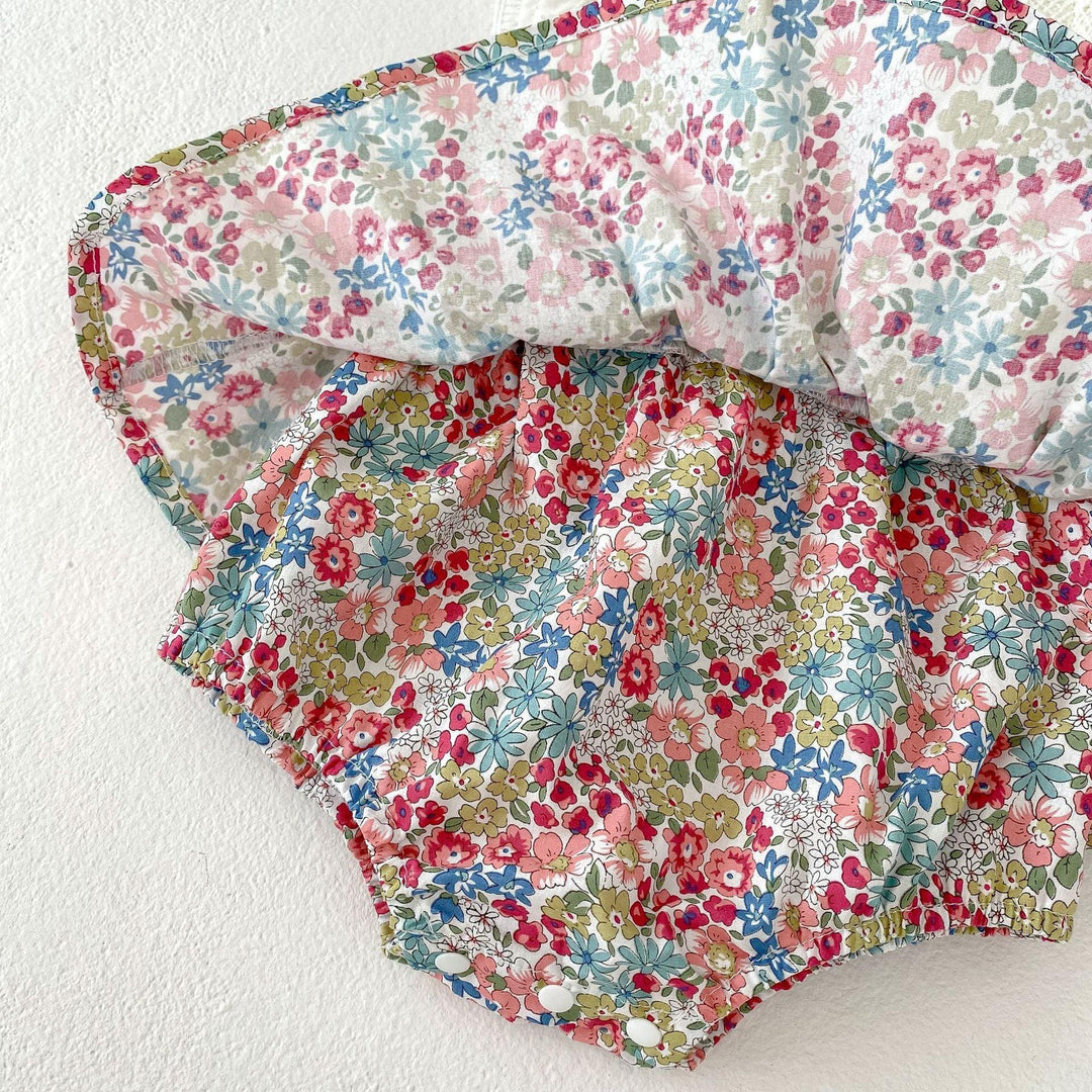 Colorful baby bloomers with elastic waist and leg openings, featuring pink, blue, and green floral print fabric