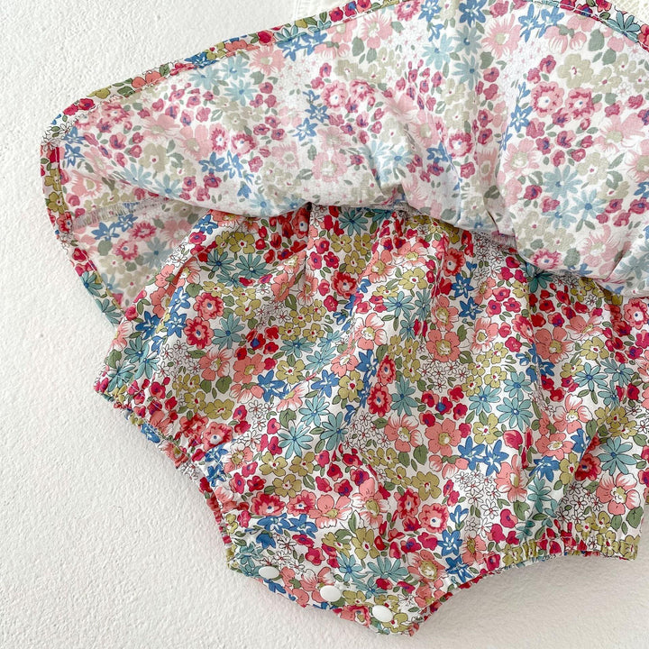 Colorful baby bloomers with elastic waist and leg openings, featuring pink, blue, and green floral print fabric