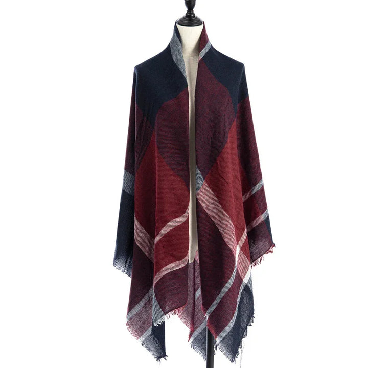 Red and navy blue plaid shawl with fringe, displayed on a mannequin against white background