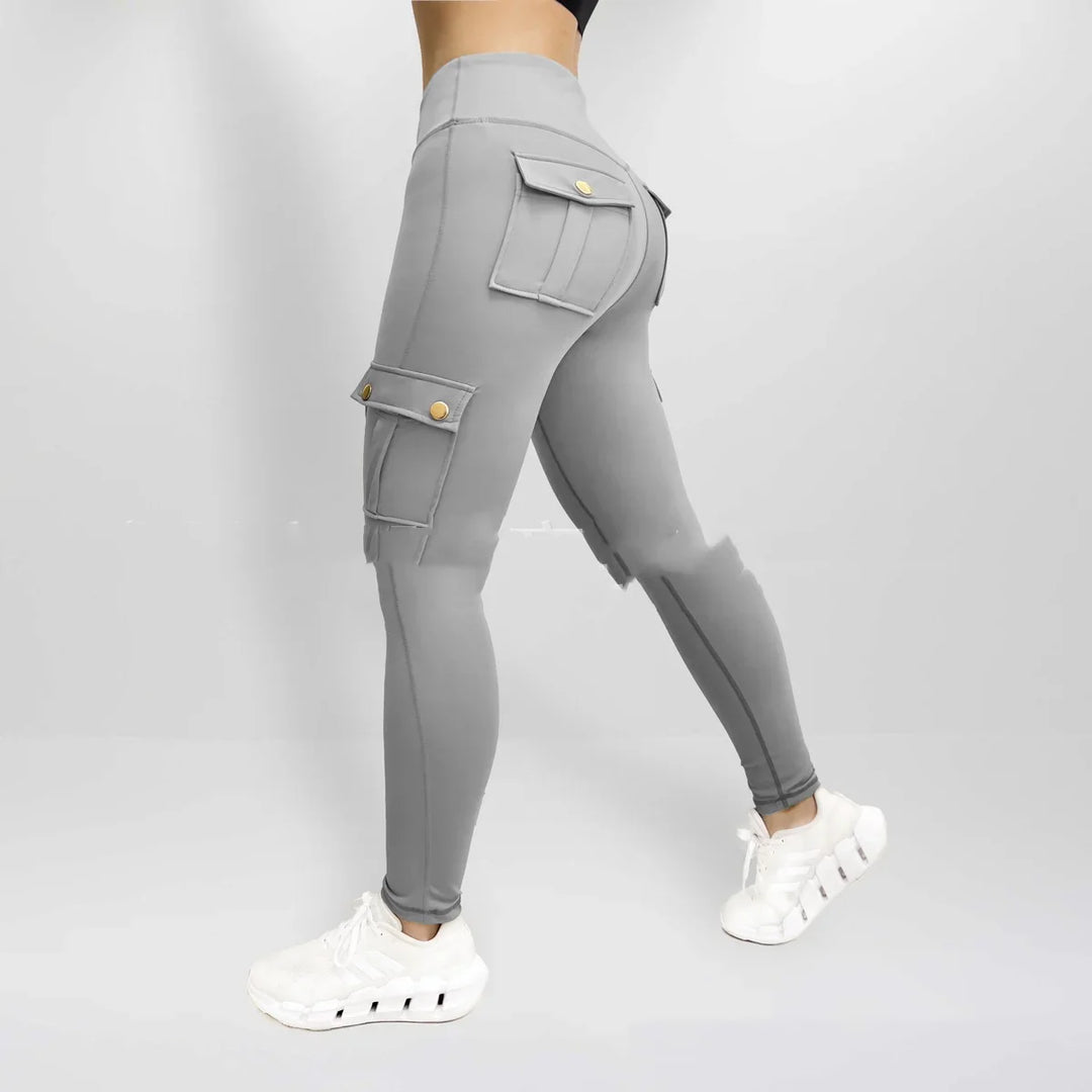 Back view of person wearing gray cargo leggings with flap pockets and white sneakers on gray background
