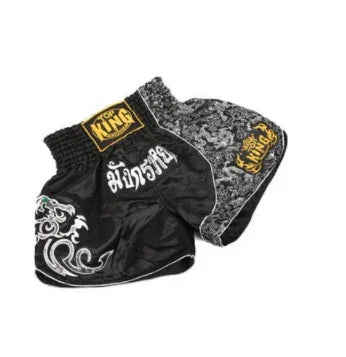 Black Muay Thai shorts with white Thai script, dragon design, and gold 'Top King' logo