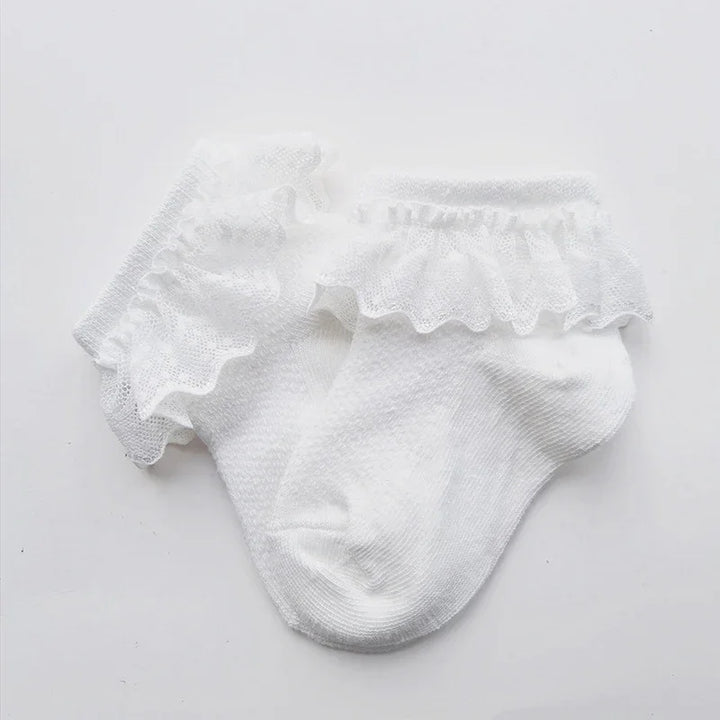 Pair of white baby socks with delicate ruffled lace trim on a white background