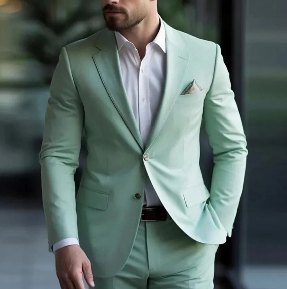 Man wearing mint green suit with white dress shirt and pocket square in modern indoor setting