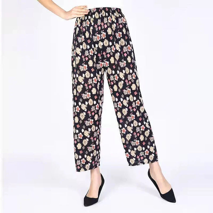 Woman wearing black floral print elastic waist wide-leg pants with black pointed toe heels