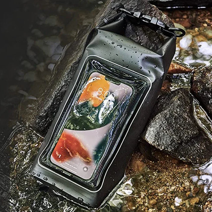 Smartphone in waterproof pouch floating in stream on rocks, protective phone case outdoors
