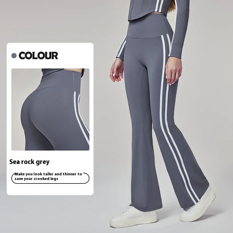 Woman wearing sea rock grey high-waisted flared leggings with white side stripes and white sneakers