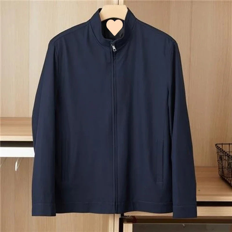 Men's navy blue zip-up jacket hanging on wooden hanger in minimal wooden closet