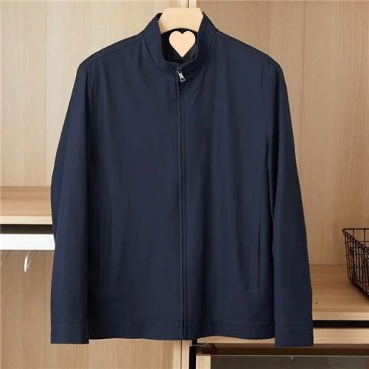 Navy blue men's casual zip-up jacket hanging on wooden hanger against wooden background