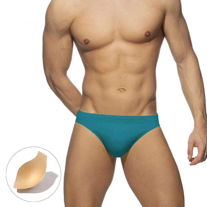muscular male torso wearing teal men's underwear briefs with removable beige padding insert