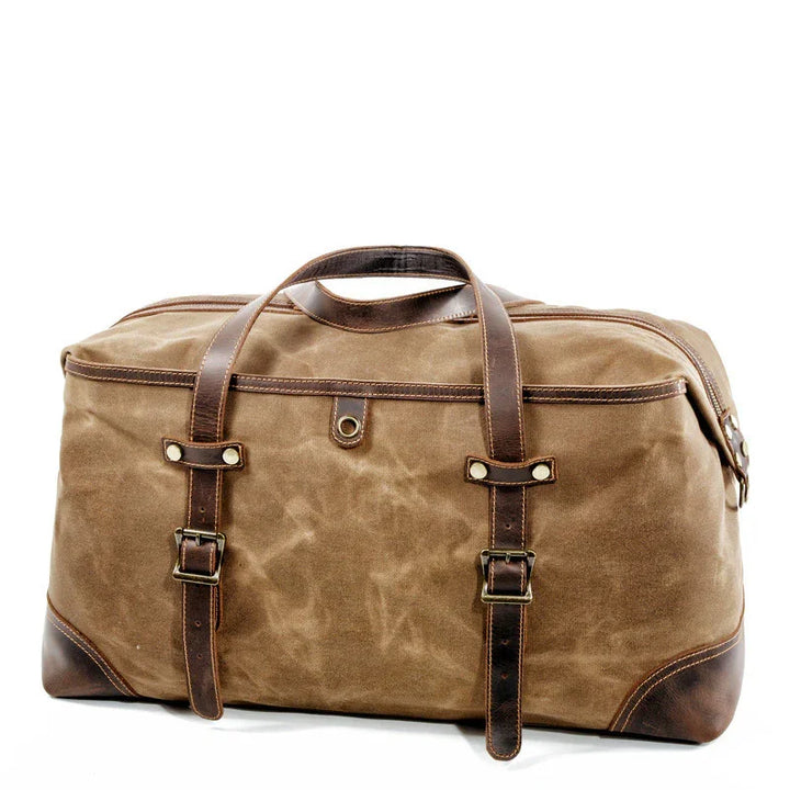 Brown canvas and leather travel duffel bag with buckle straps and handles on white background