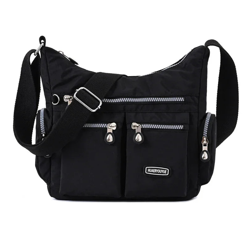 Black crossbody nylon bag with multiple zippered pockets and adjustable strap