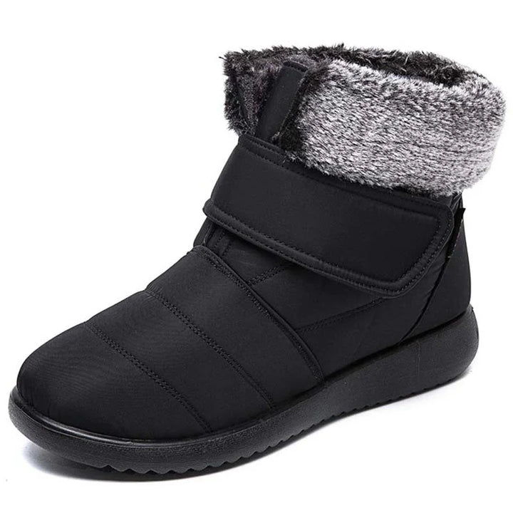 Black winter boot with padded upper, velcro strap, and gray faux fur lining
