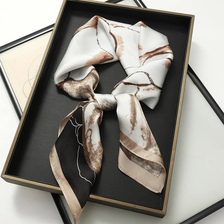 Elegant silk scarf with brown and black abstract patterns displayed in a black gift box