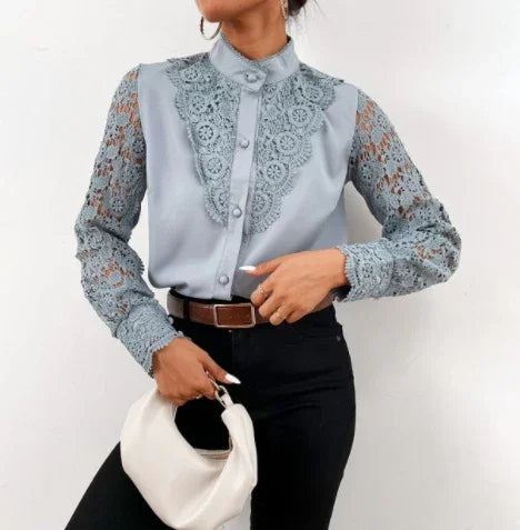 Woman wearing elegant light blue lace blouse with high collar and black pants, holding white handbag