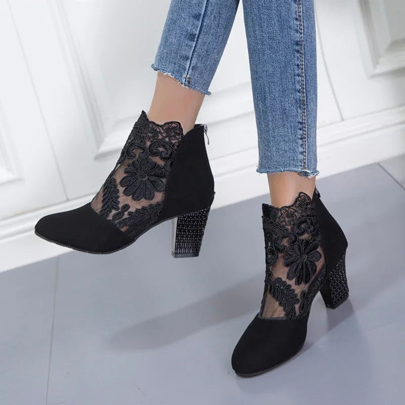 Black lace ankle boots with floral embroidery and block heels worn with blue frayed hem jeans