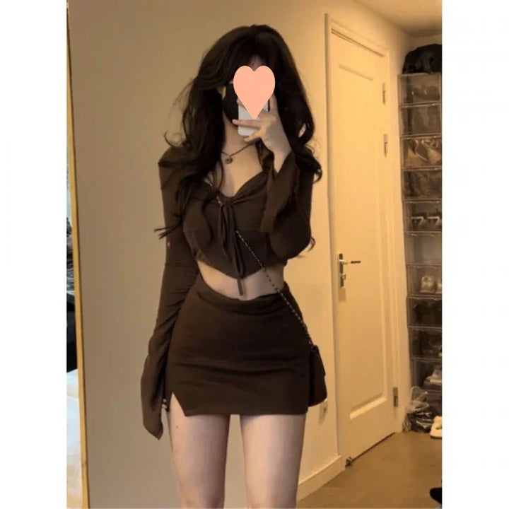 Woman in brown cropped top and mini skirt taking mirror selfie in bedroom with shoe organizer