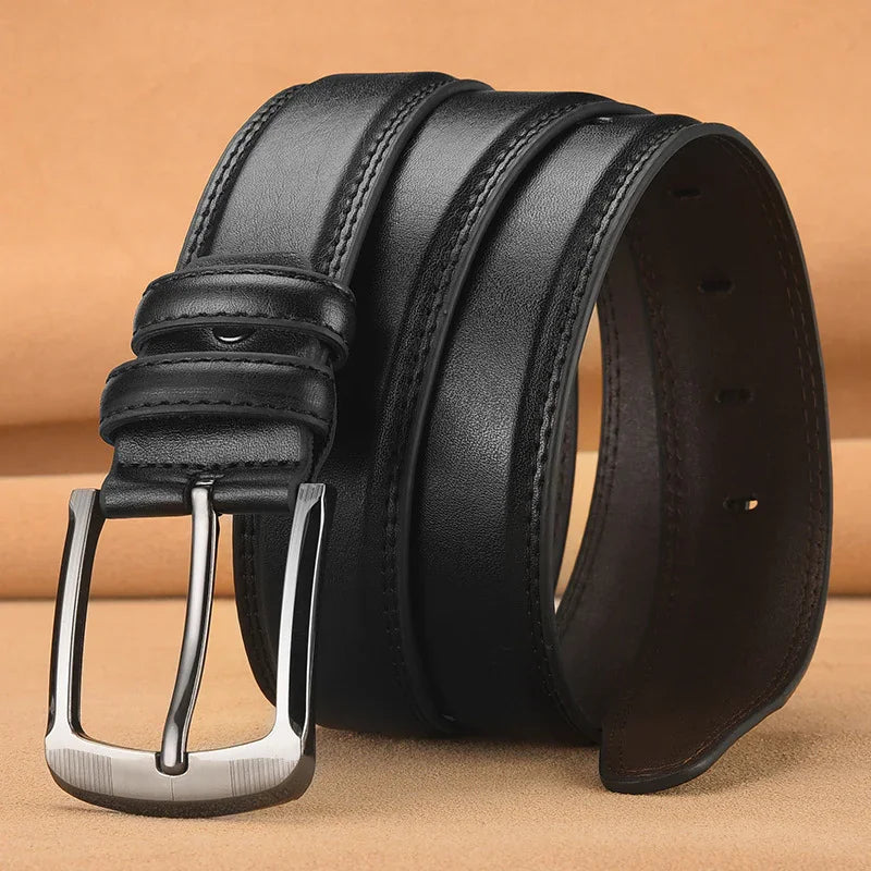 Black leather belt with silver metal buckle rolled on tan background, men's fashion accessory