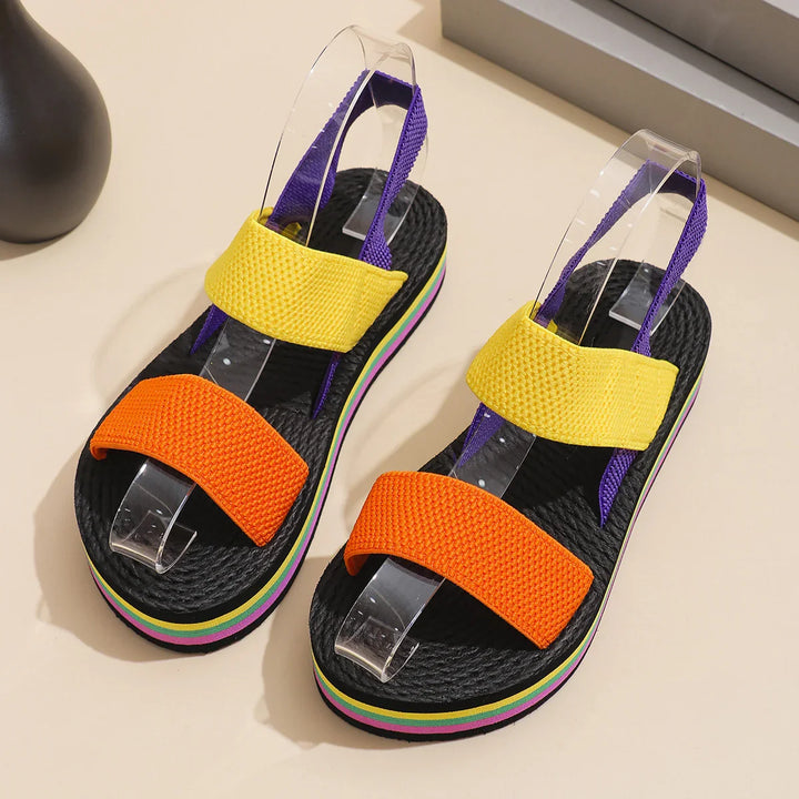 Colorful platform sandals with orange and yellow straps, purple slingback, and striped soles