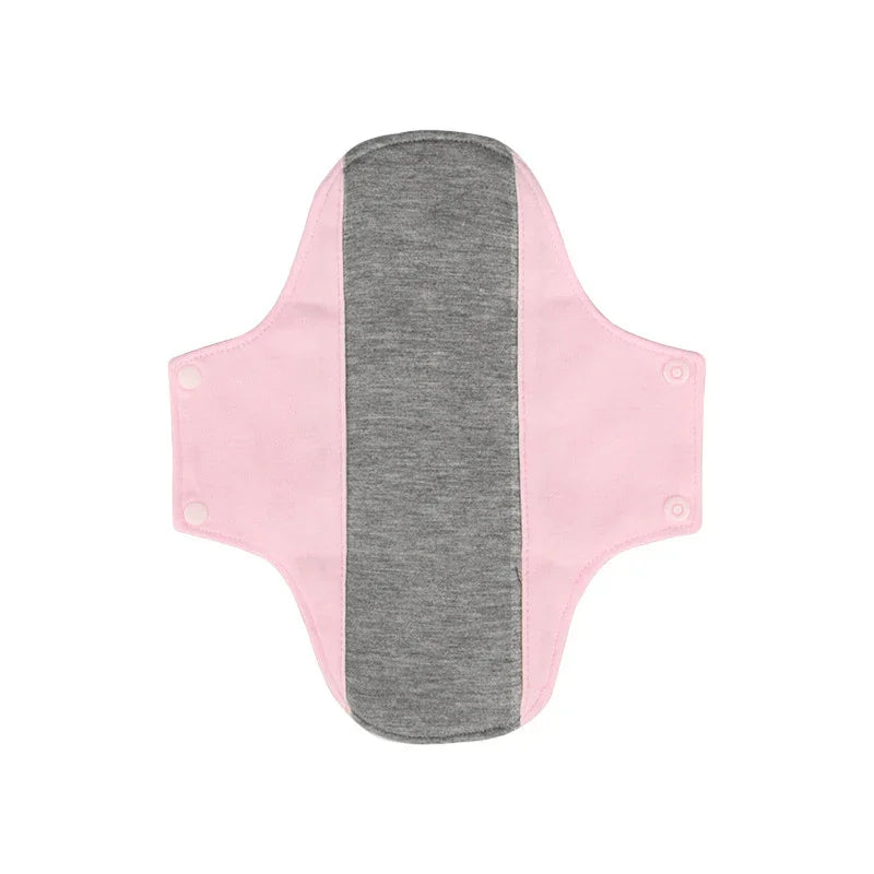 Reusable cloth menstrual pad with light pink wings and dark gray absorbent center, snap buttons