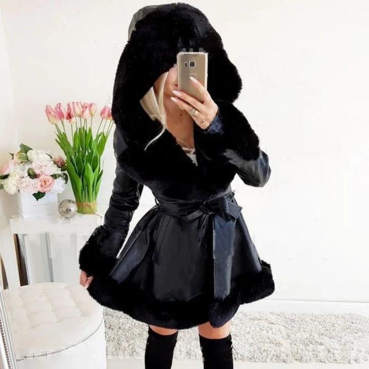 Woman wearing black faux fur trim hooded leather coat and thigh-high boots taking mirror selfie