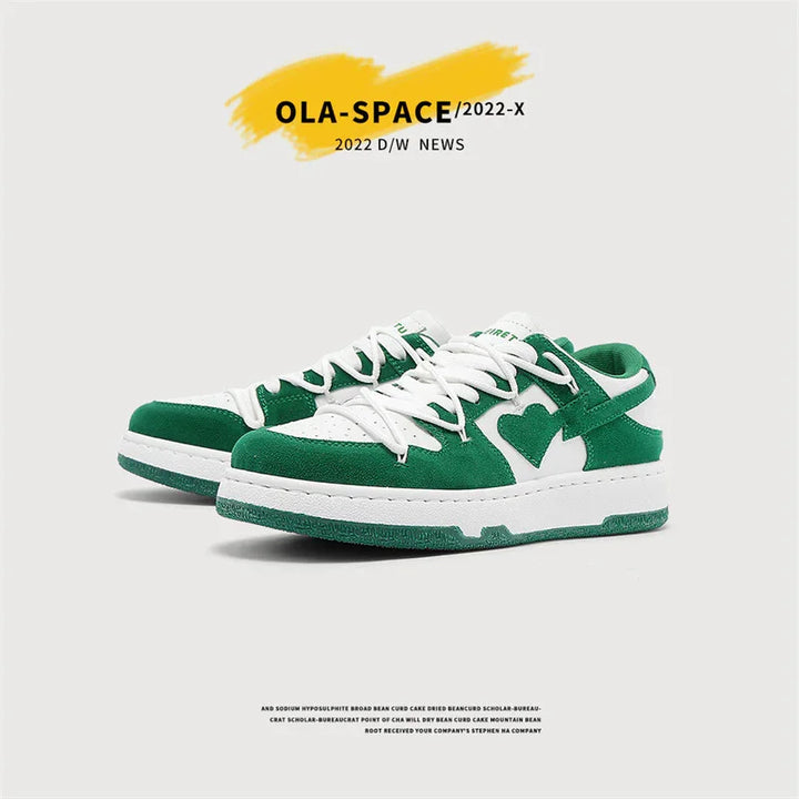 Green and white low-top sneakers with heart design, white laces, and textured sole on plain background