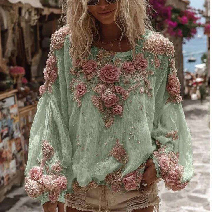 Woman wearing mint green blouse with pink 3D floral embroidery and beige shorts on sunny street