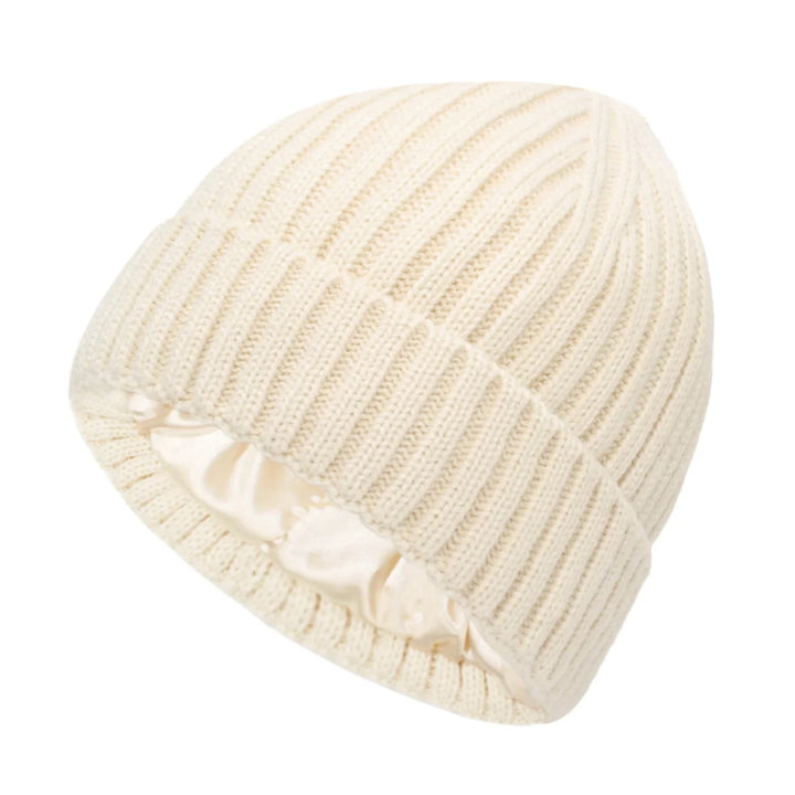 Cream-colored ribbed knit beanie hat with folded cuff and satin interior lining