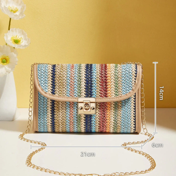 Colorful striped woven crossbody bag with gold chain strap and clasp lock on yellow background