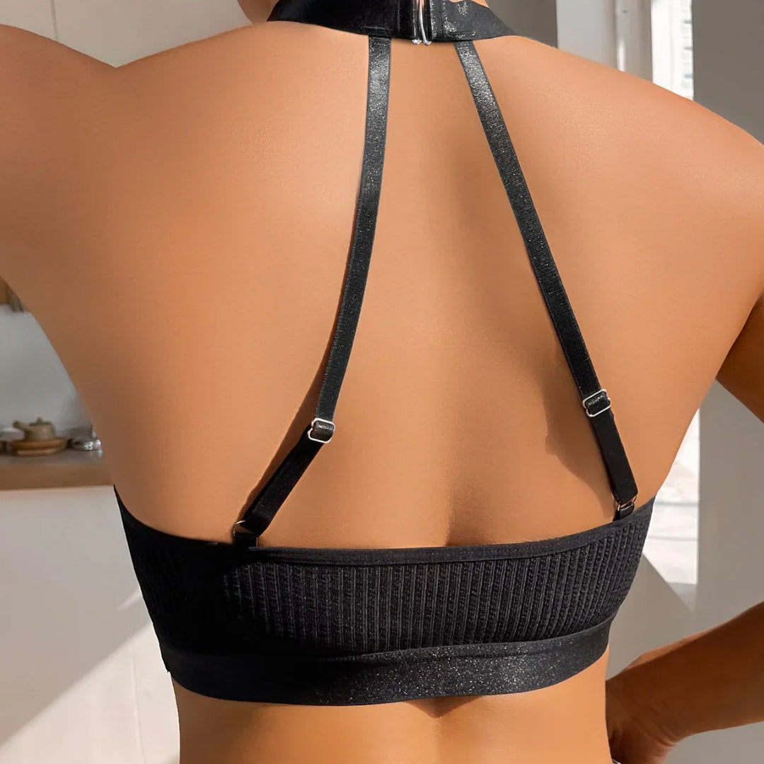 Back view of person wearing black ribbed crop top with thin adjustable straps in bright indoor setting