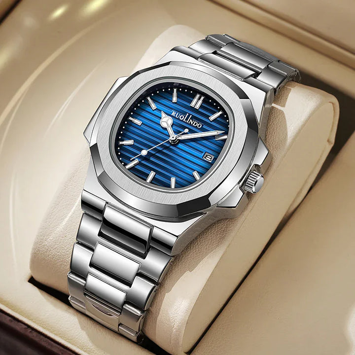 Luxury silver stainless steel wristwatch with blue striped dial and date display on beige cushion