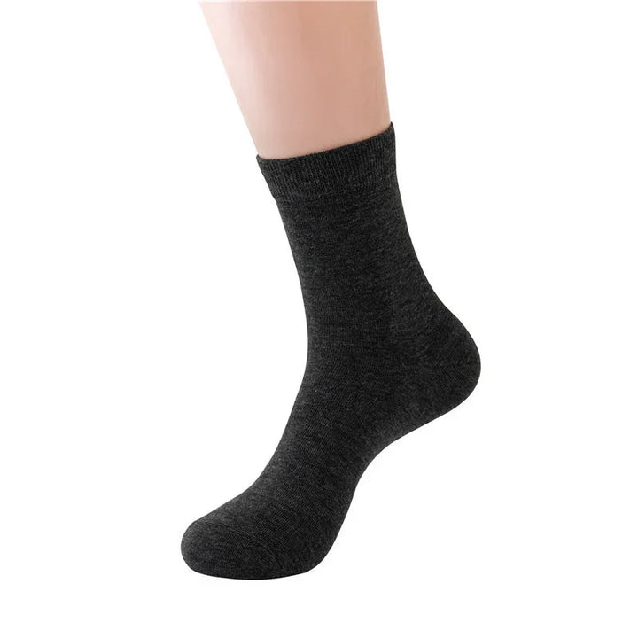 single dark gray ankle sock on a mannequin foot against white background