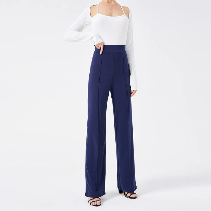 Woman wearing navy high-waisted wide-leg pants and white cold shoulder top with black sandals