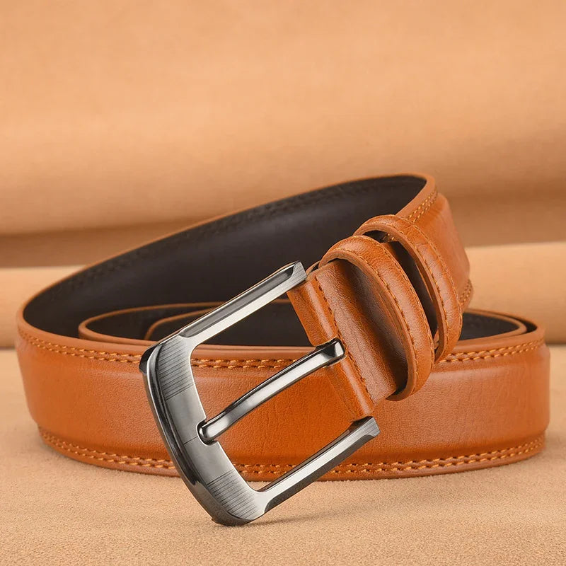 Brown leather belt with silver buckle on beige background, stitched edges visible