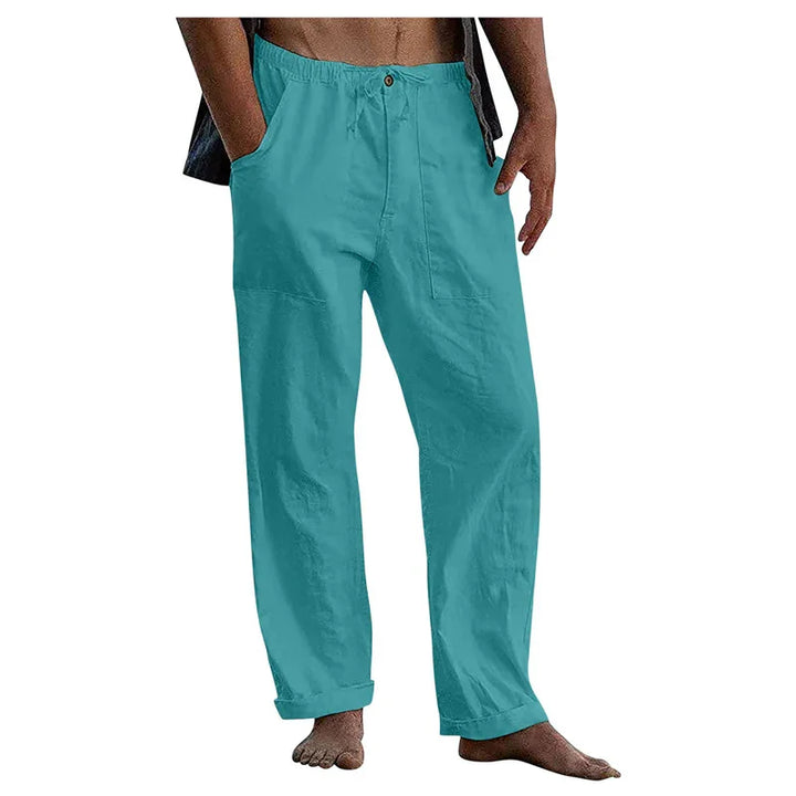 Men's casual teal linen pants with elastic waist and pockets, barefoot model