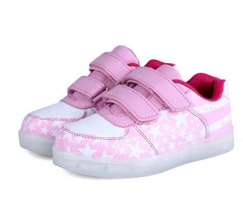 Pink and white kids' sneakers with star patterns and velcro straps on a white background