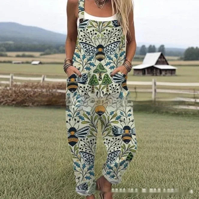 Woman wearing floral and bee patterned overalls in a rural field with a barn backdrop