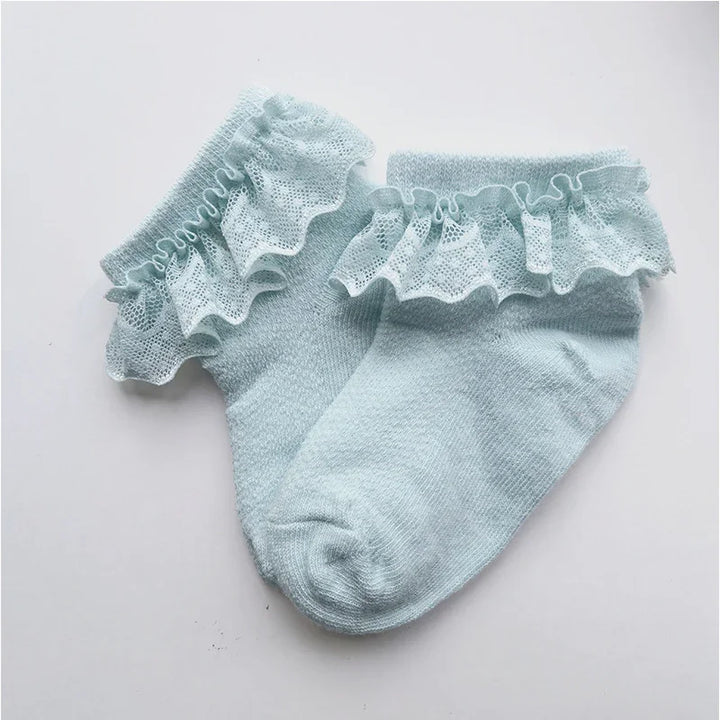 Pair of light blue baby socks with delicate lace ruffle trim on white background