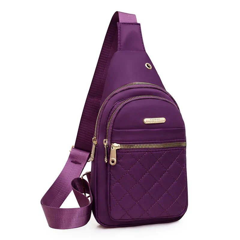 Purple quilted crossbody sling bag with gold zippers and adjustable strap
